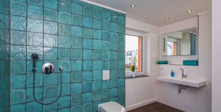 Das Badezimmer ist modern gestaltet, die schwellenlose Dusche fügt sich übergangslos in den Raum ein. Copyright: Heinz von Heiden GmbH Massivhäuser