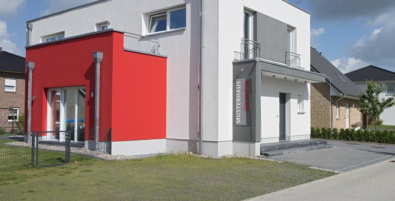 Mit einer Fassadengestaltung in Weiß, Rot und Grau ist das Musterhaus Glinde ein echter Hingucker. Copyright: Heinz von Heiden GmbH Massivhäuser