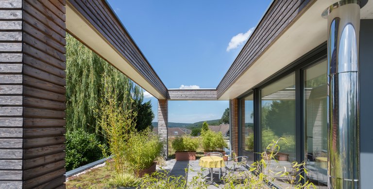 Auf der grünen, naturverbundenen Terrasse lässt es sich zu jeder Jahreszeit aushalten. Copyright: ZimmerMeisterHaus/Guido Schiefer