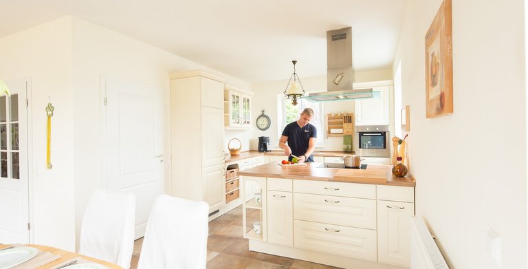 Die helle Küche im Landhausdesign mit Essbereich ist direkt mit dem Wohnbereich verbunden.  Copyright: Heinz von Heiden GmbH Massivhäuser