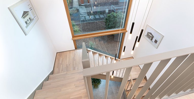 Eine offene dreiläufige Podesttreppe verbindet die beiden Wohnetagen Copyright: TALBAU-Haus GmbH
